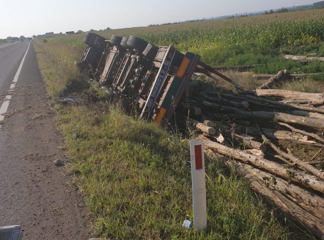 Un şofer din Harghita s-a răsturnat cu un camion plin de lemne